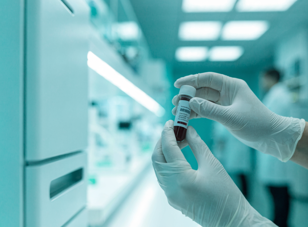 Laboratory technician holding a labelled blood sample tube